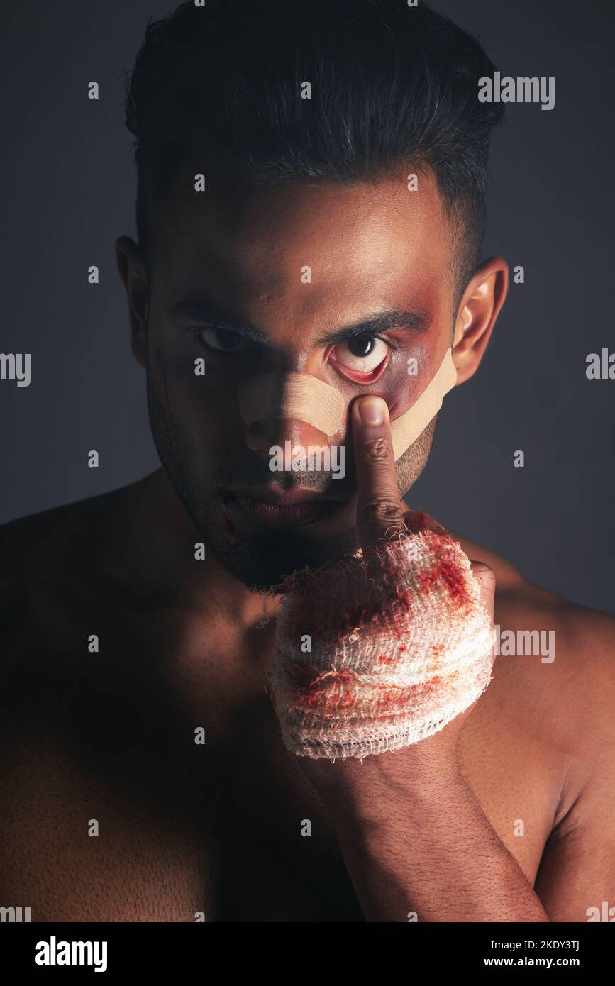 Sang, blessure à la boxe et homme avec des meurtrissures de conflit de combat, de violence criminelle ou de crime sombre avec le signe emoji du milieu du doigt. Shadow, style de vie rebelle Banque D'Images