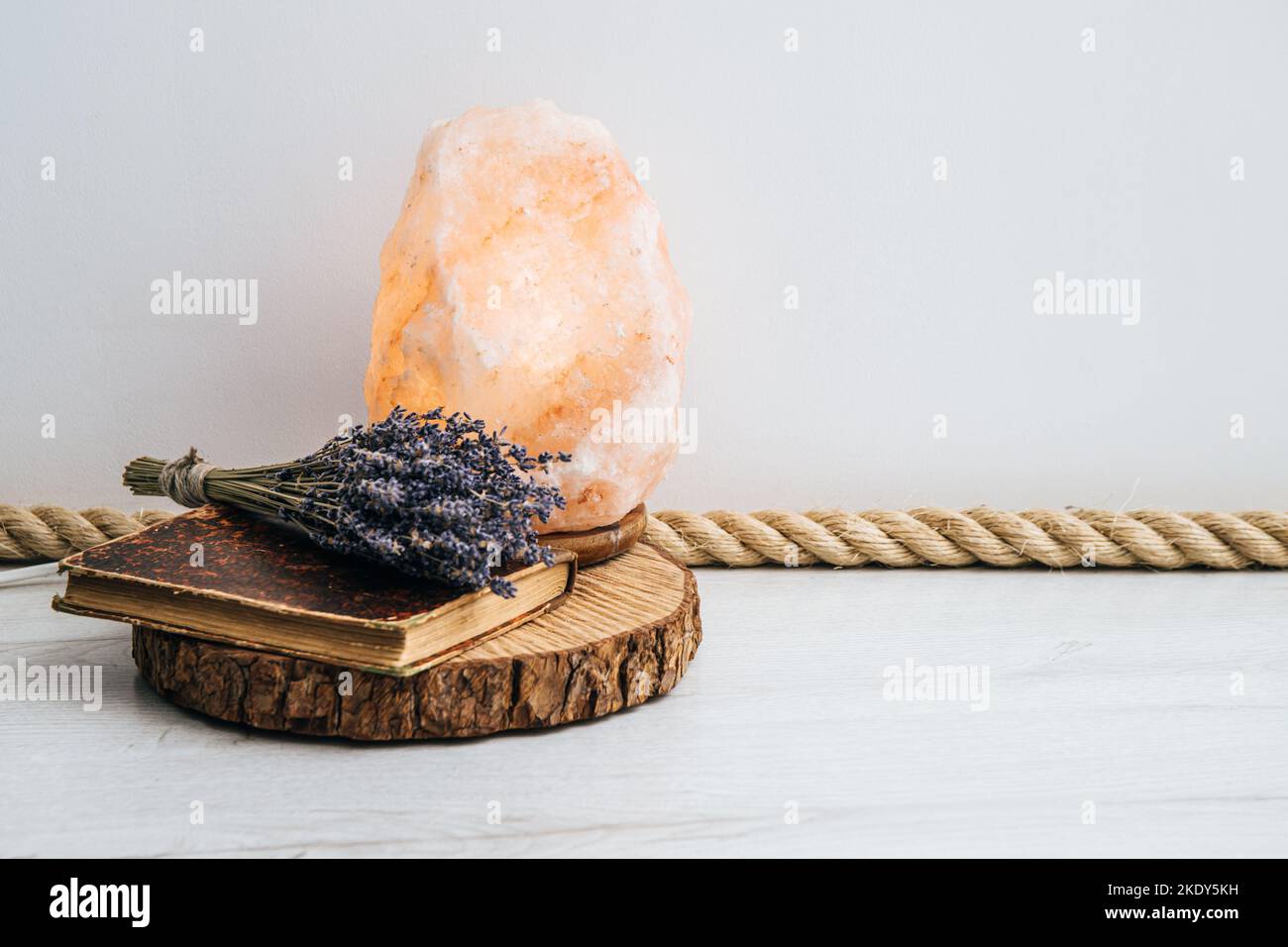 Utiliser une corde de jute comme garniture de plancher, élément de conception de la maison de boho. Sol blanc de la salle de séjour avec garniture en corde de jute, plateau à disques en bois, livre vintage et lavande séchée. Banque D'Images