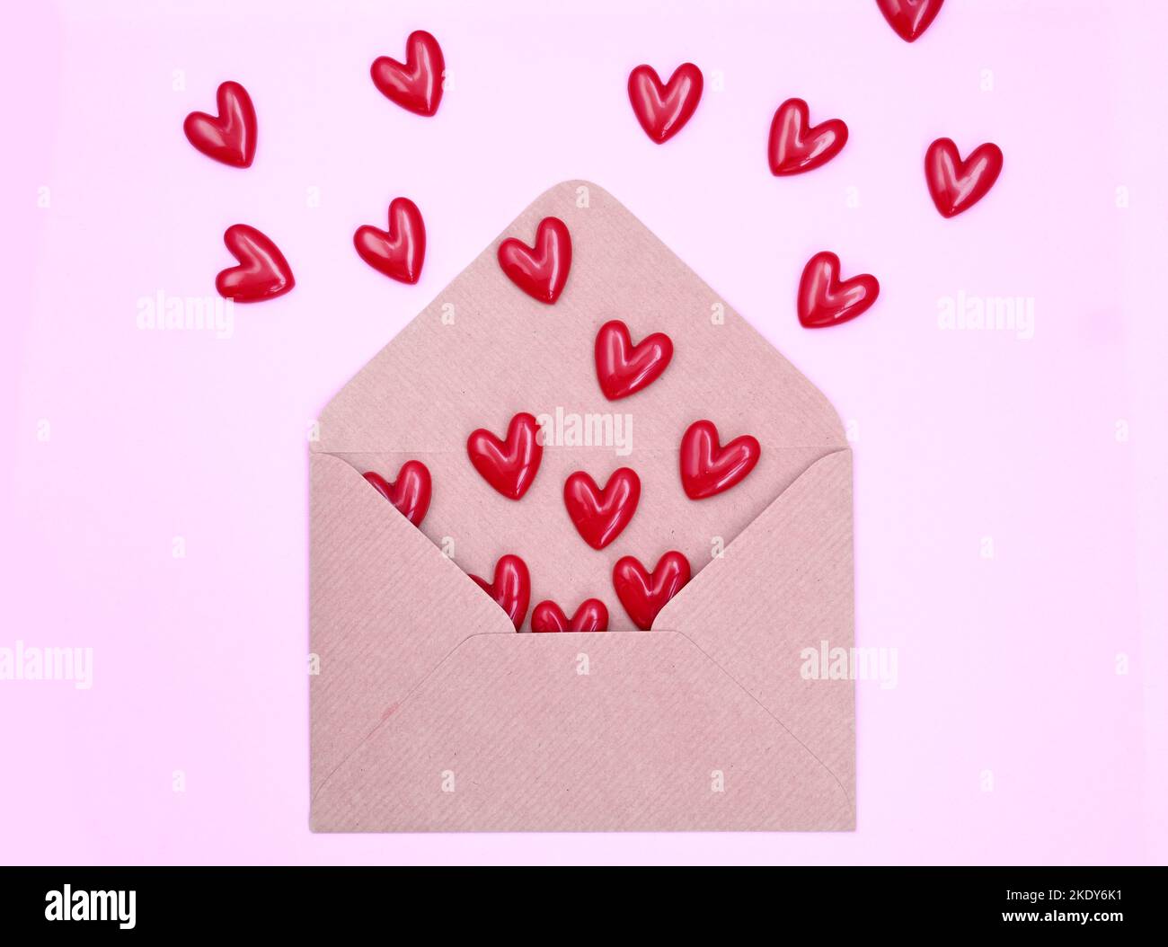 Enveloppe et coeurs rouges sur fond rose. Concept de Saint-Valentin, amour, anniversaire Banque D'Images