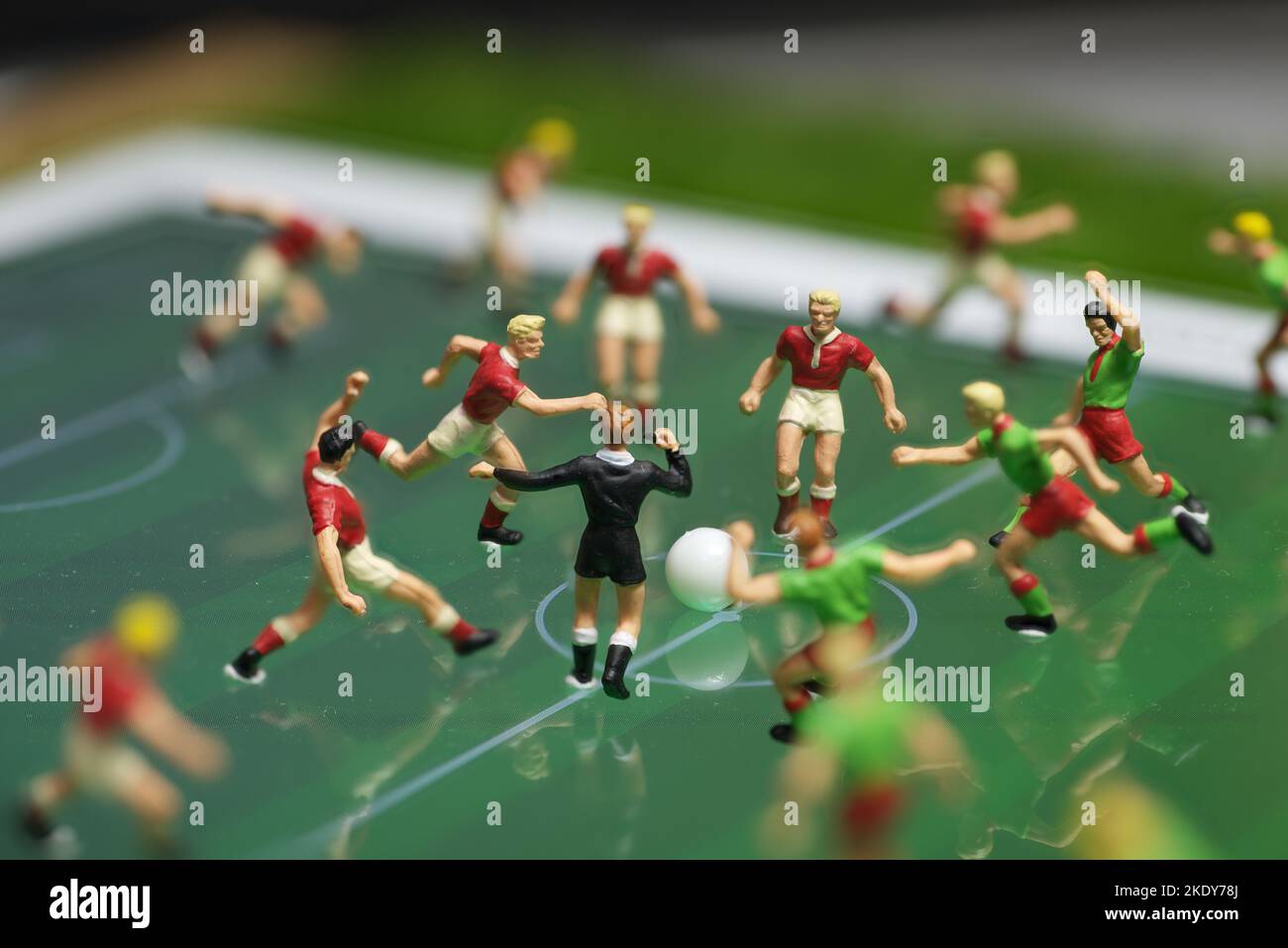 Vue latérale des jouets miniatures figurines joueurs de football (soccer) sur un pavé électronique d'ordinateur (accent sur l'arbitre). Banque D'Images