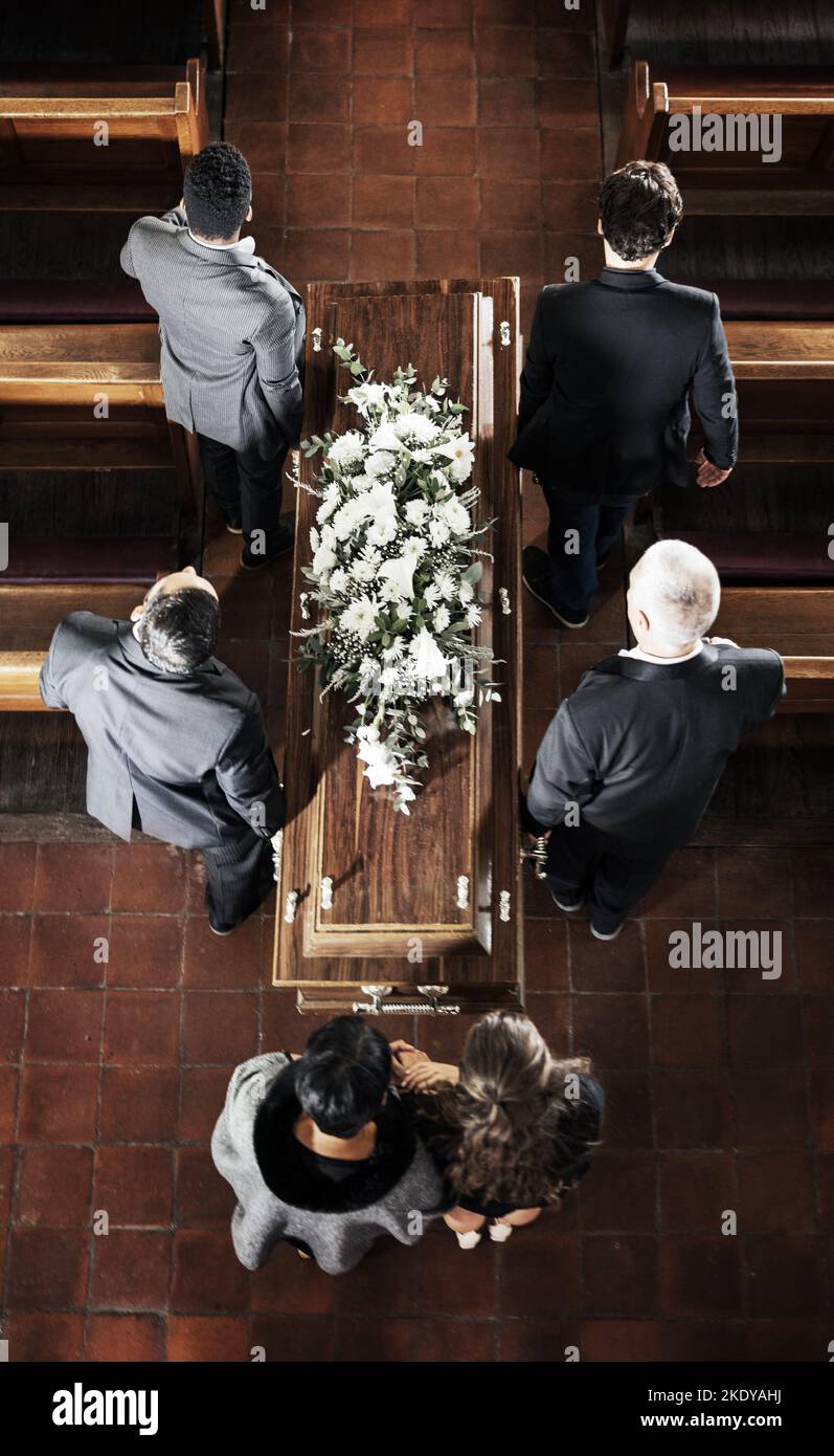 Funérailles, cercueil et famille pleurant la mort de l'être aimé, la mort et portant des cercueils en bois dans l'église pour le réveil de foi, l'éloge et le mémorial. Pallers Banque D'Images