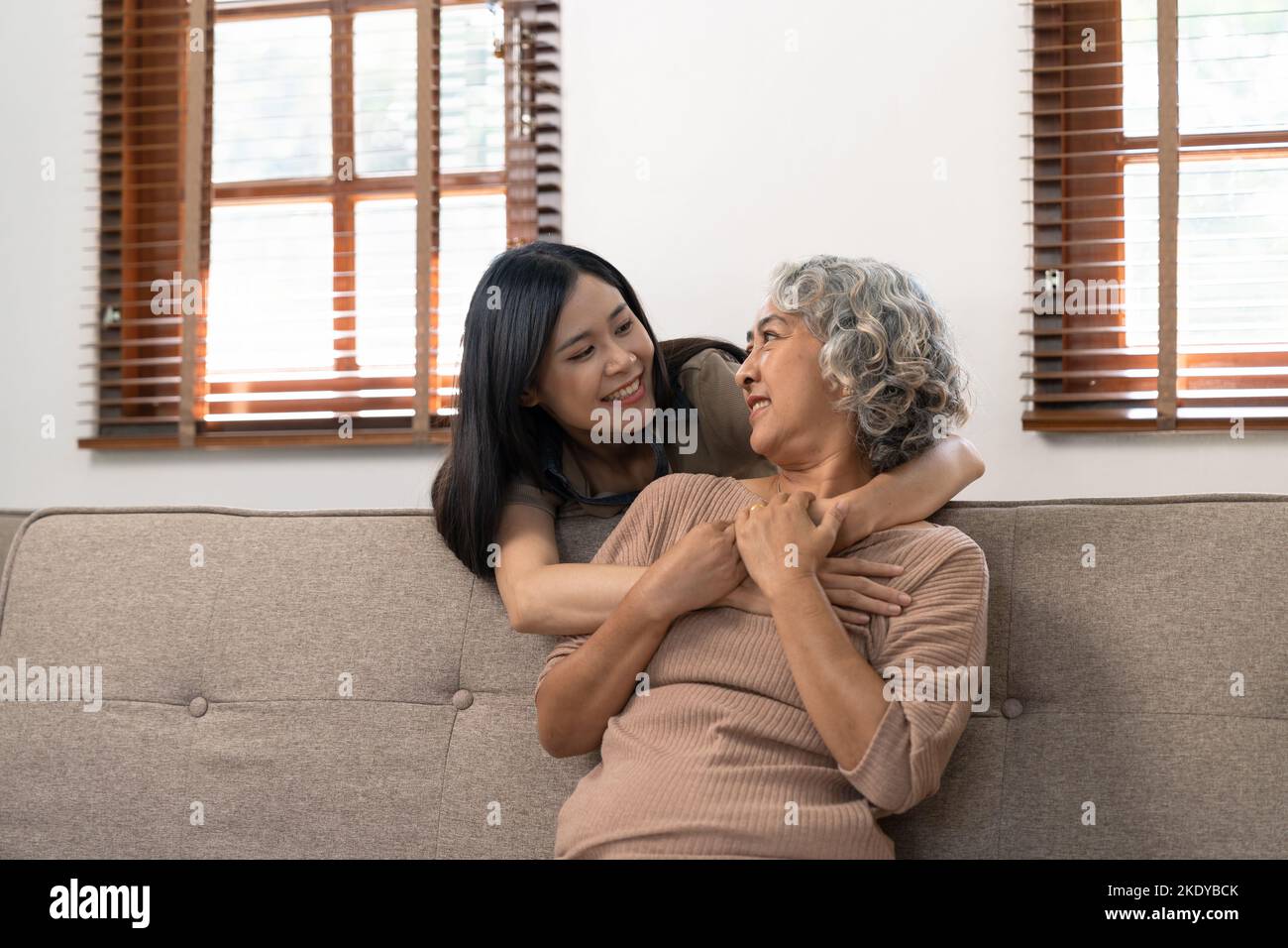 fille grognée souriante embrassant une mère âgée. concept de deux générations, belle jeune femme embrassant une femme mûre, posant pour la photo ensemble. Banque D'Images