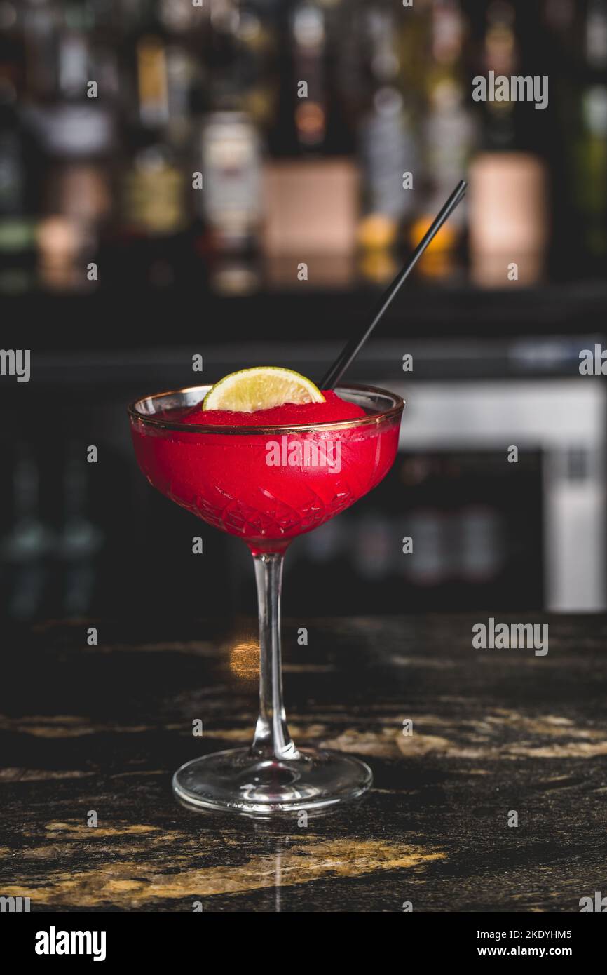 Un gros plan vertical d'un cocktail cosmopolite dans un verre dans un café Banque D'Images