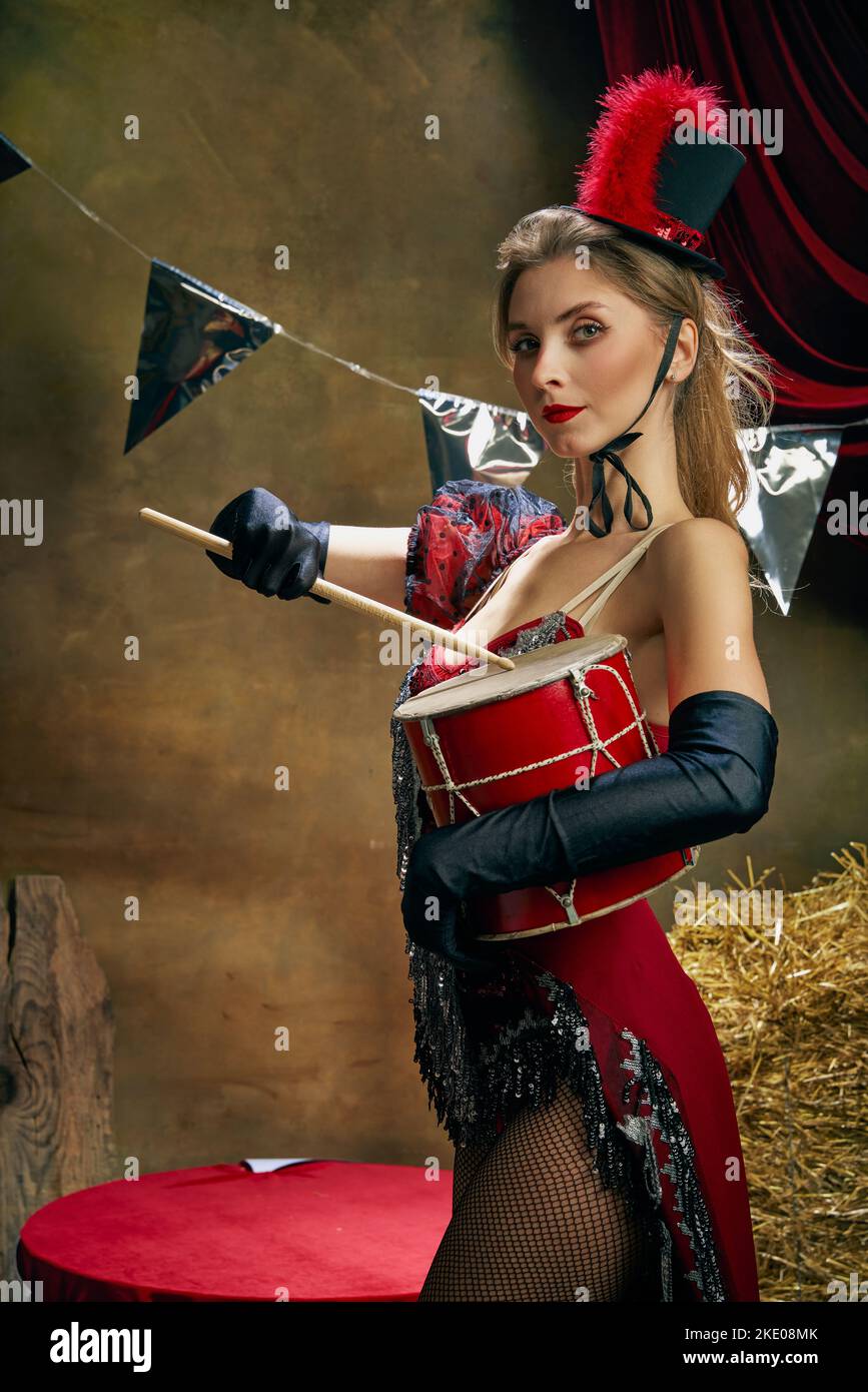 Portrait vintage de l'adorable belle actrice de cirque rétro sur fond sombre de cirque rétro. Concept des émotions, de l'art, de la mode, du style Banque D'Images