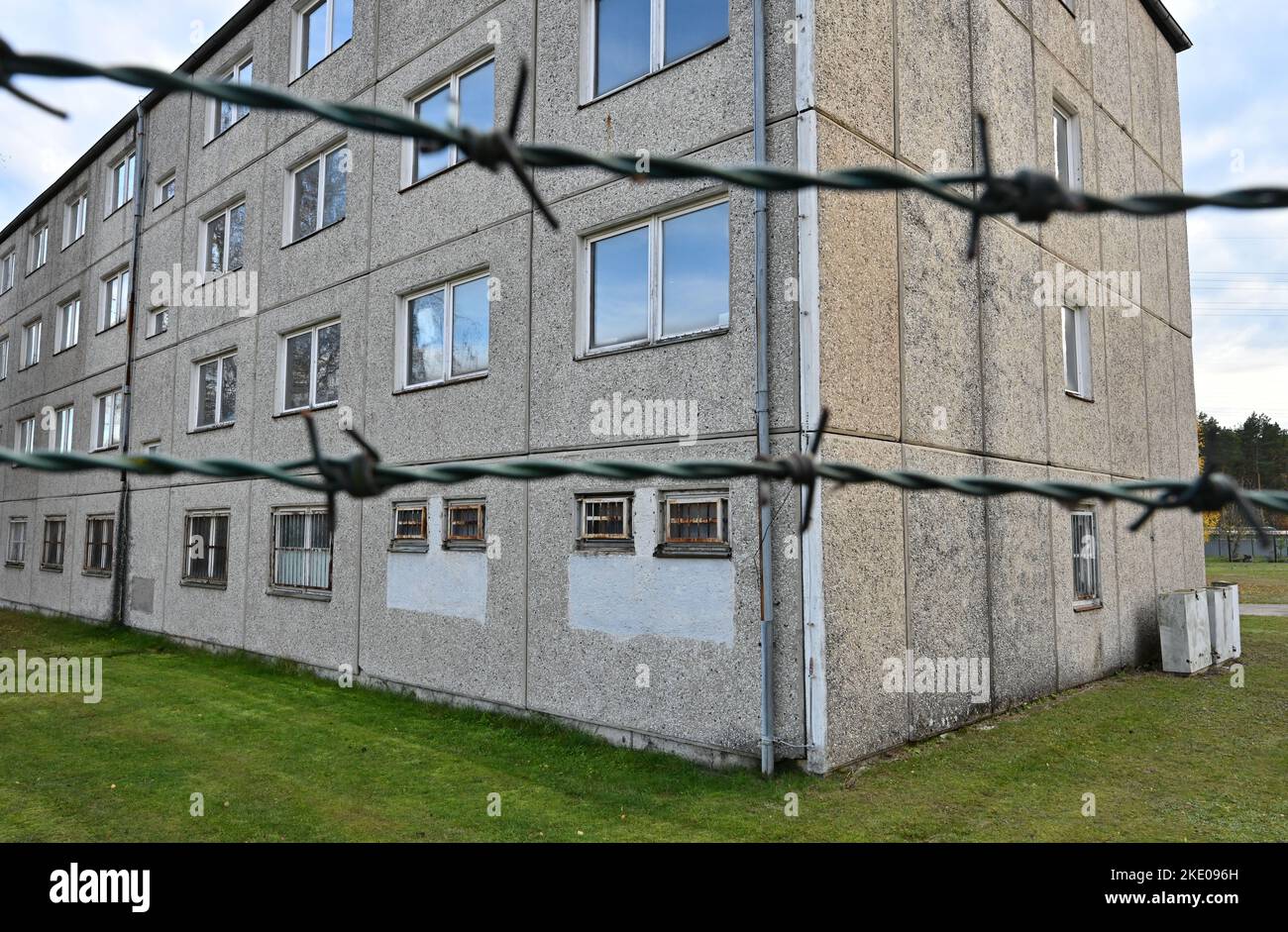 09 novembre 2022, Brandebourg, Schwedt: Barbelés peut être vu en face d'un bâtiment préfabriqué qui a été utilisé comme une prison militaire de NVA à l'époque de GDR. Le même jour, l'événement central de l'État de Brandebourg commémorant la chute du mur de Berlin sur 9 novembre 1989, a eu lieu à Schwedt. C'était un hommage à l'événement exceptionnel de la Révolution pacifique et à ceux qui se sont révoltés et ont contribué à la chute du régime SED. Dans le même temps, les souffrances et l'injustice infligées aux prisonniers de la prison militaire et de l'unité disciplinaire de Schwedt ont été rappelées. PPB Banque D'Images