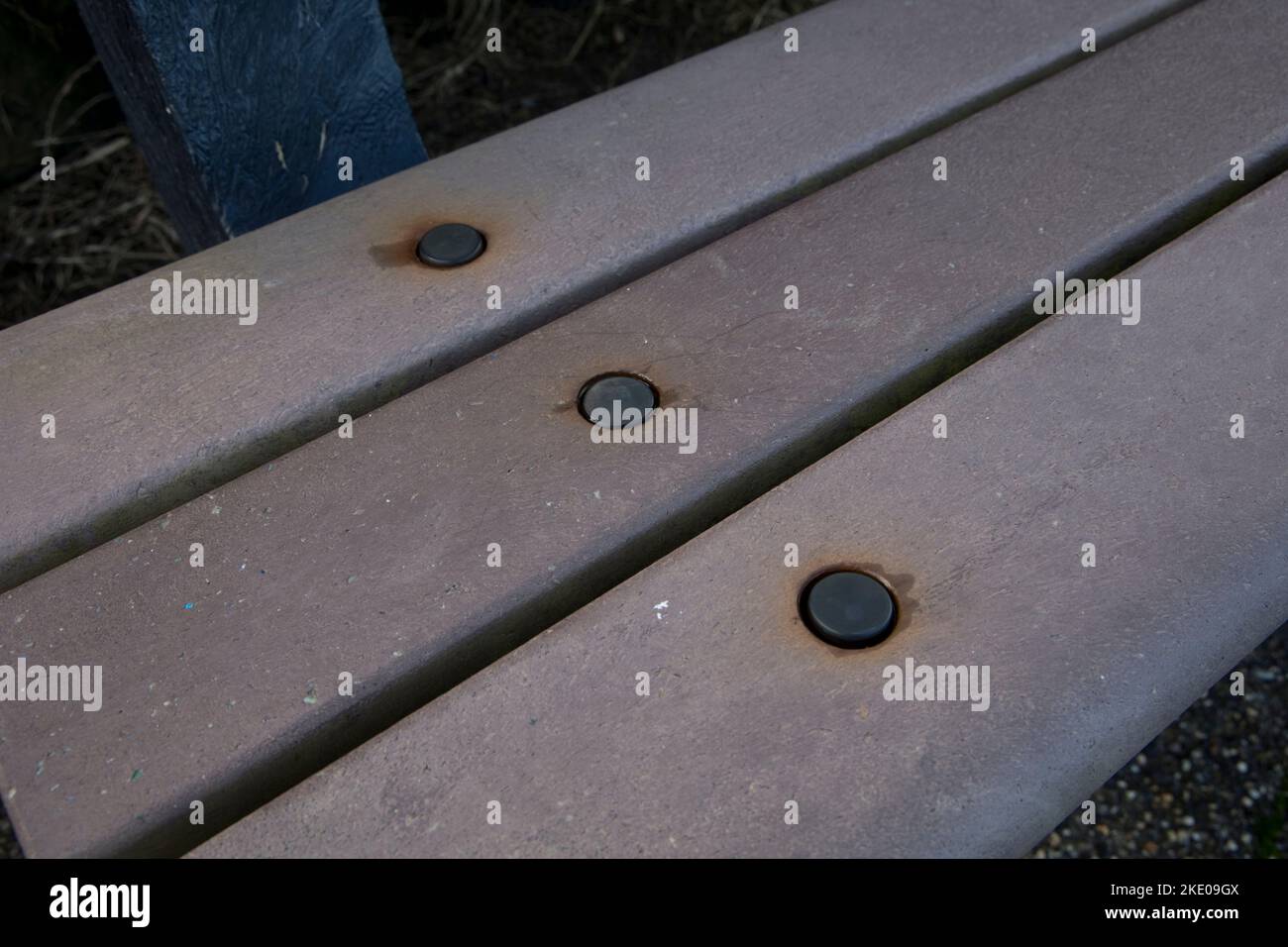 Boulons rouillés dans une banquette en bois de plastique imperméable à l'épreuve des intempéries en bois de mémorial fait de déchets de plastique agricole utilisés sur la promenade Ilfracombe Devon Banque D'Images