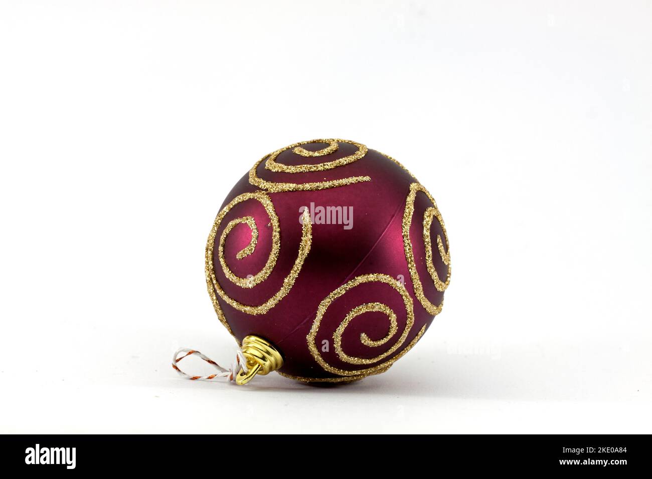 Boule de Noël rouge avec bandes dorées isolées sur fond blanc Banque D'Images