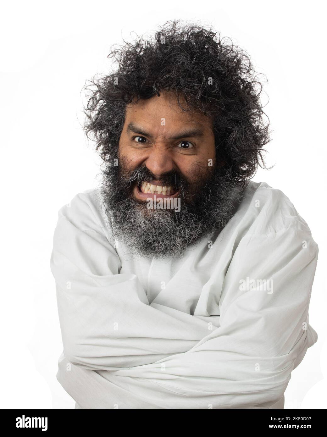 Un portrait vertical d'un psychopathe mâle meulant des dents dans un manteau de straitjay Banque D'Images