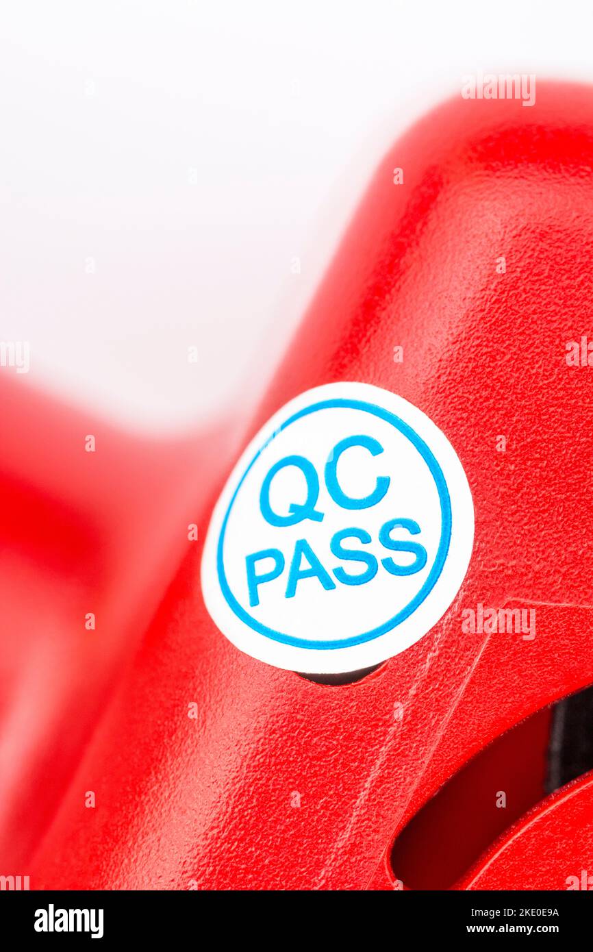 Gros plan de l'étiquette de papier adhésif QC Pass en papier bleu et blanc sur le côté du produit générique fabriqué en chinois. Pour passer le contrôle qualité, concept de CQ. Banque D'Images
