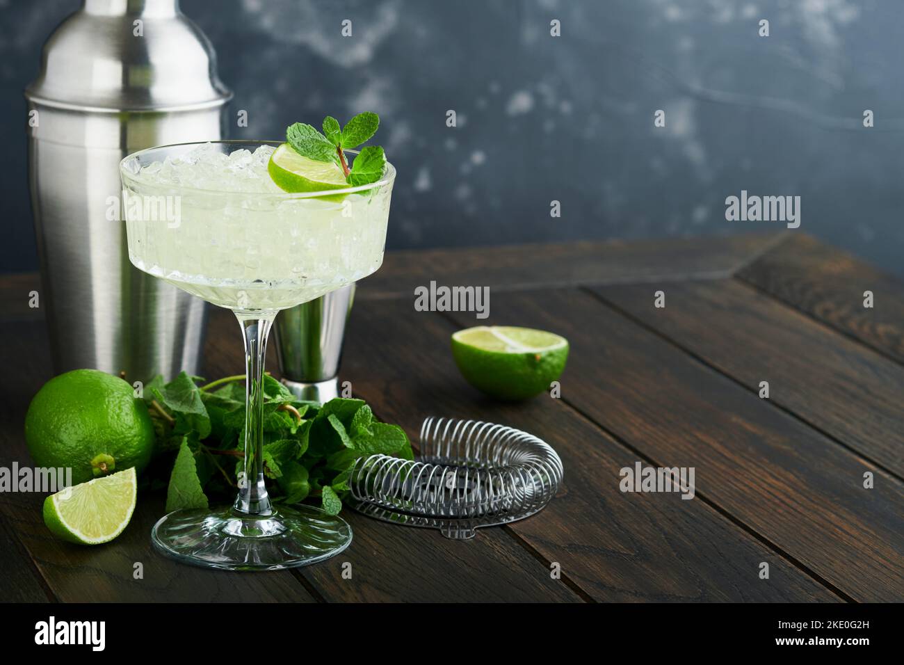 Cocktail de Margarita avec citron vert, tequila, menthe et glace sur table sombre avec rétroéclairage incroyable, espace de copie. Margarita classique ou cocktail Daiquiry. Carte à barres Banque D'Images