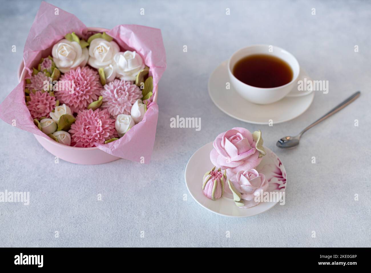 ensemble de thé dans une composition avec des fleurs de guimauve. Tasse à café sur soucoupe. Sur fond gris clair. Soirée thé revigorante le matin Banque D'Images