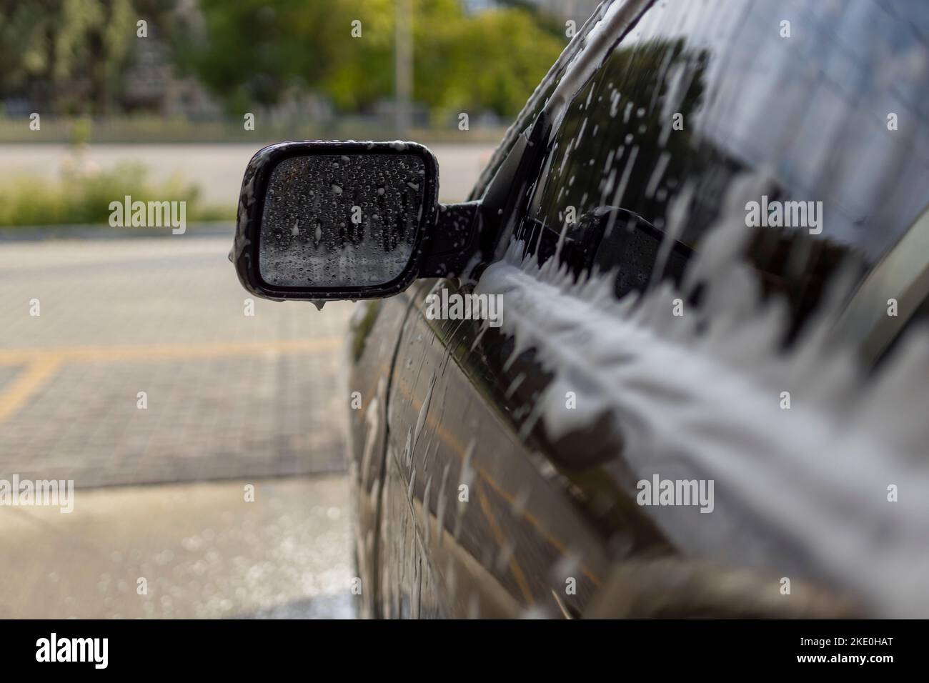 Laver les miroirs dans une voiture avec de la mousse active. Lavage de voiture. Banque D'Images