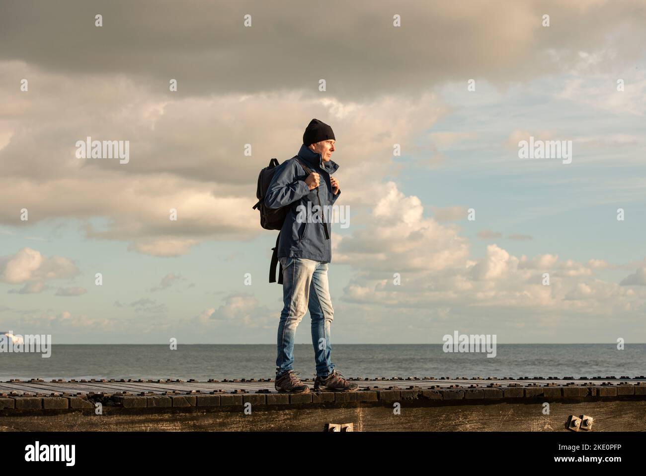 Homme avec sac à dos au bord de l'océan, automne, promenade en hiver. Banque D'Images