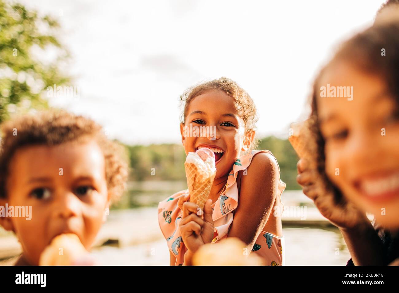 Bonne fille mangeant de la crème glacée avec la famille en vacances Banque D'Images