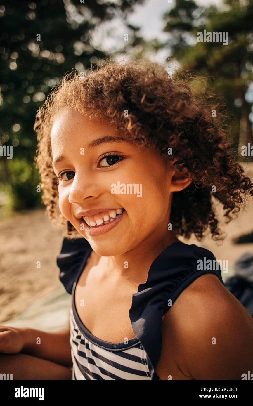 Portrait d'une fille heureuse aux cheveux bouclés pendant les vacances Banque D'Images