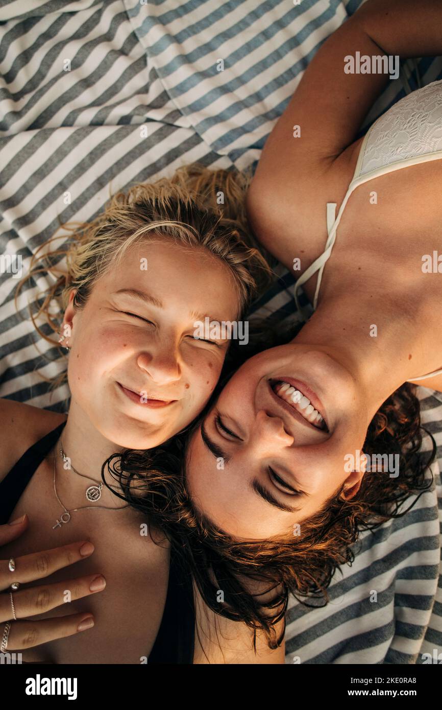 Directement au-dessus de la vue de la femme avec les yeux fermés couchés par une amie souriante Banque D'Images