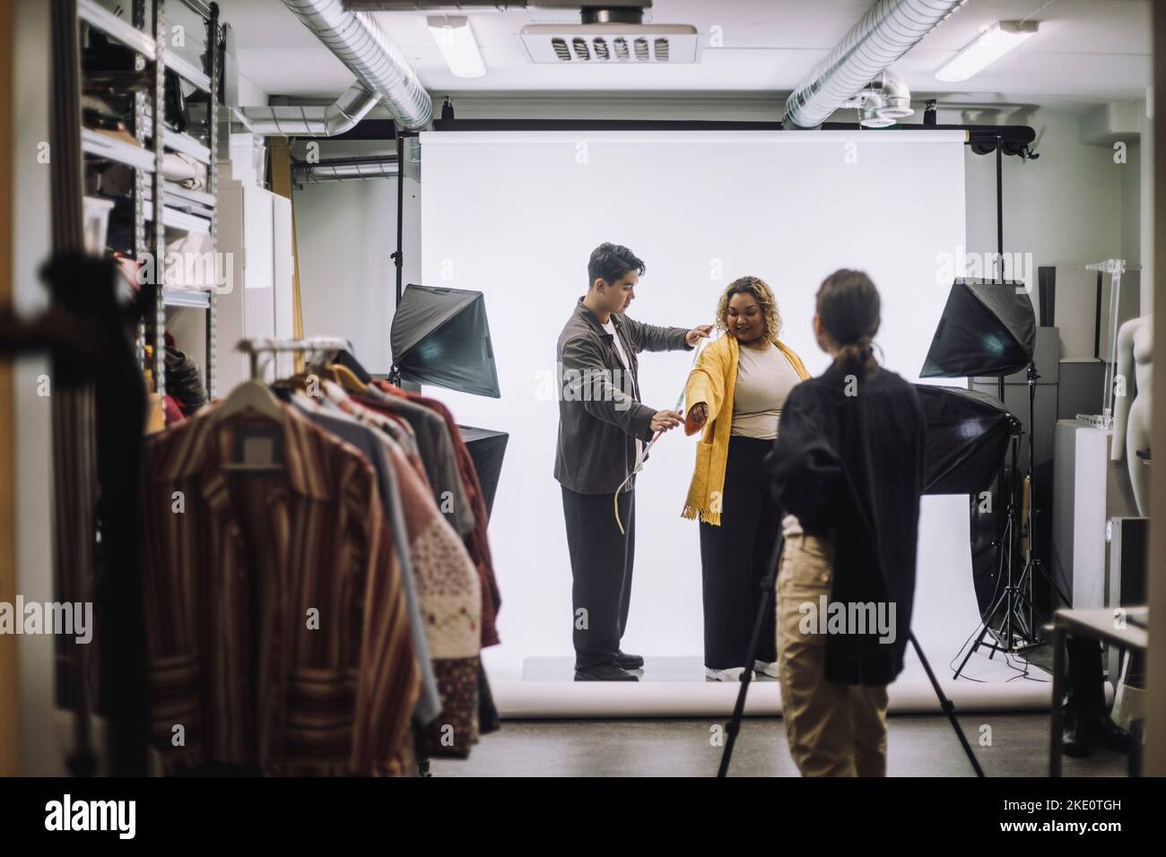 Veste de mesure professionnelle de conception masculine par modèle de mode lors de la prise de photos en studio Banque D'Images