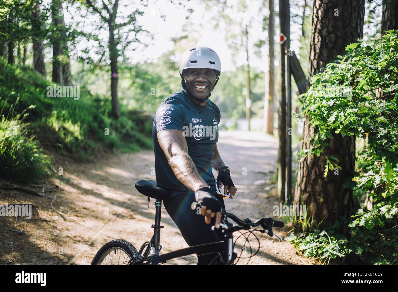 Portrait d'un homme souriant, penché en vélo sur le sentier Banque D'Images