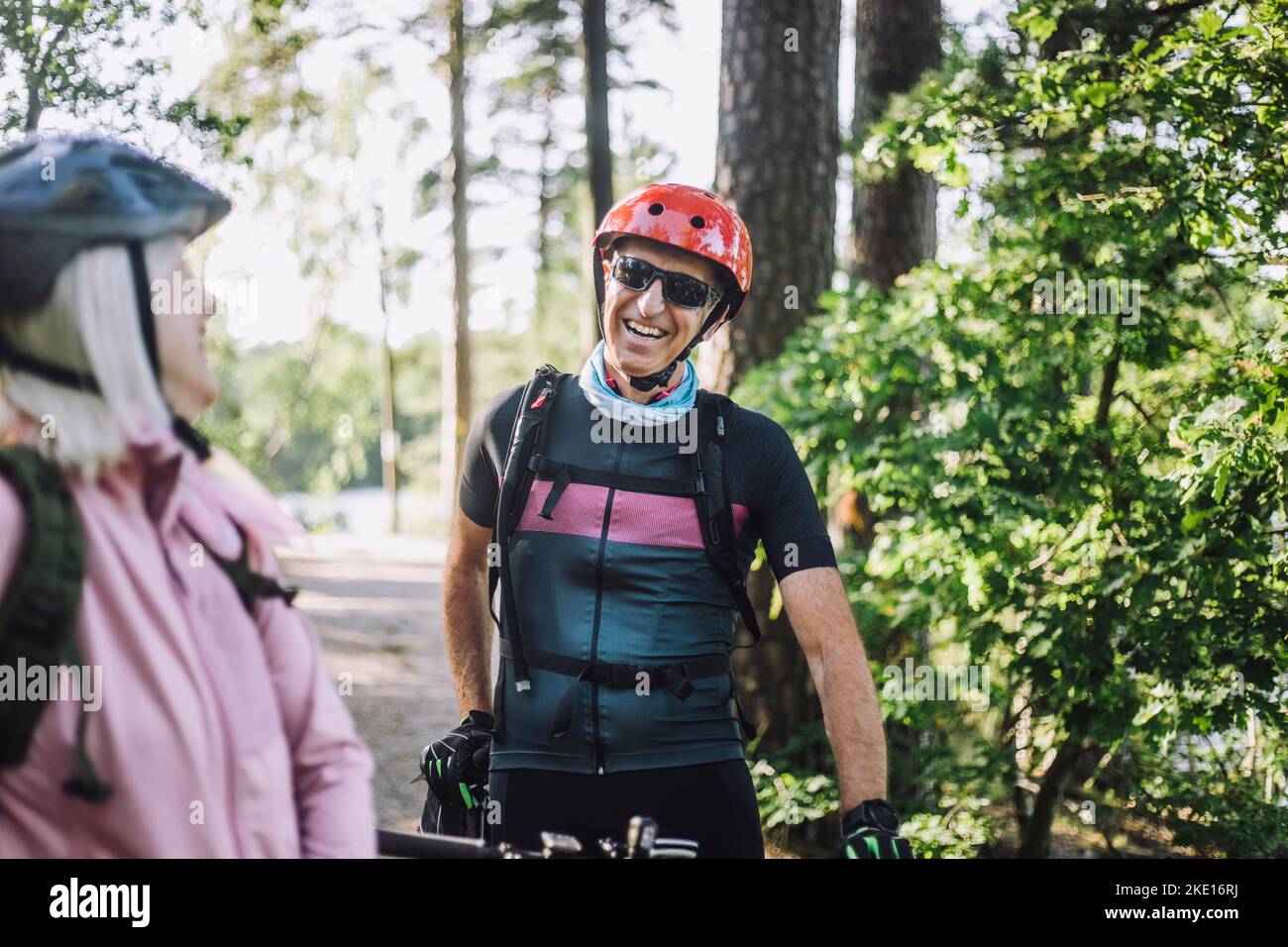 Joyeux cycliste parlant à une amie de sexe féminin Banque D'Images