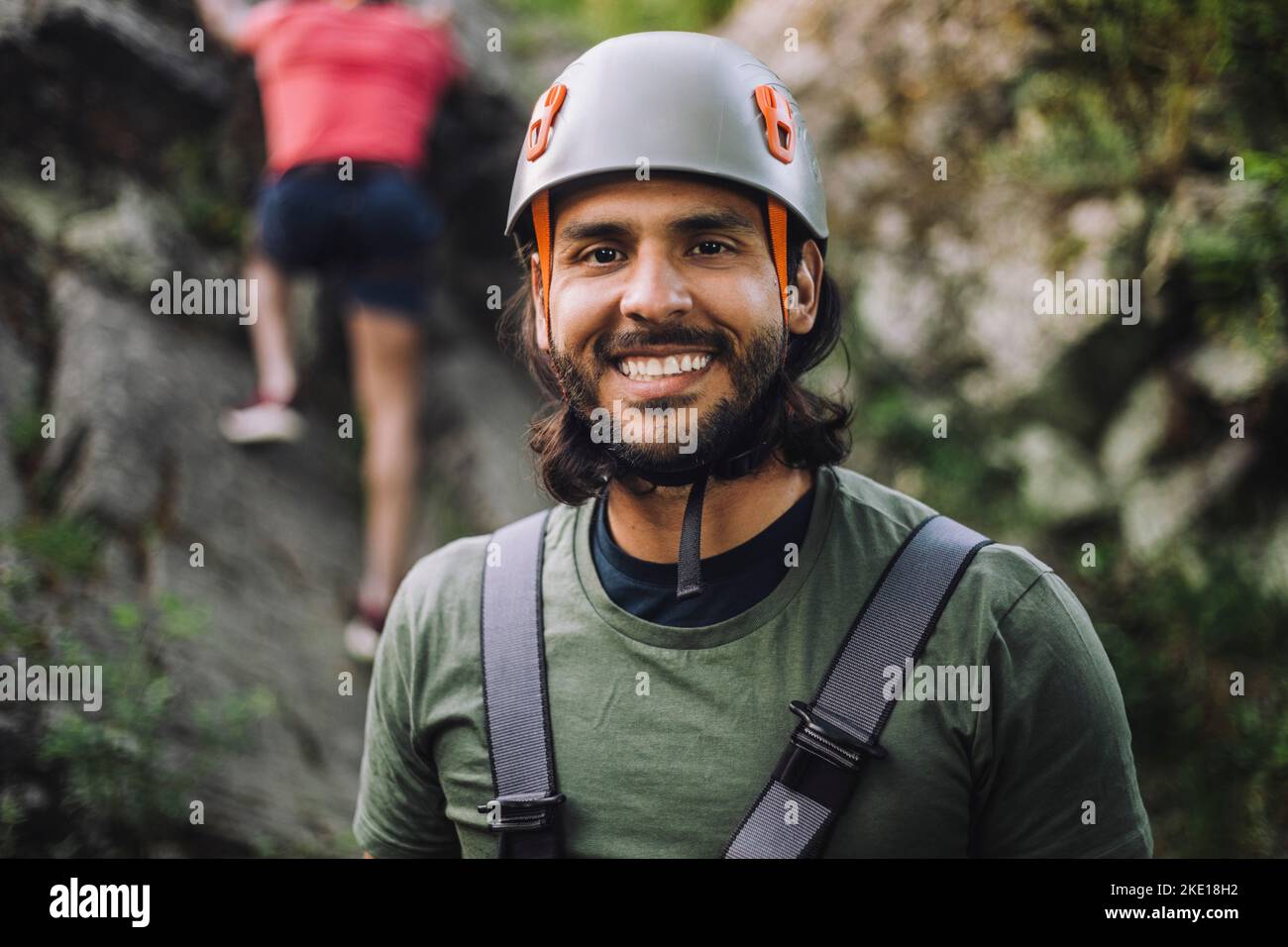 Portrait d'un homme souriant portant un casque de sport pendant l'escalade Banque D'Images