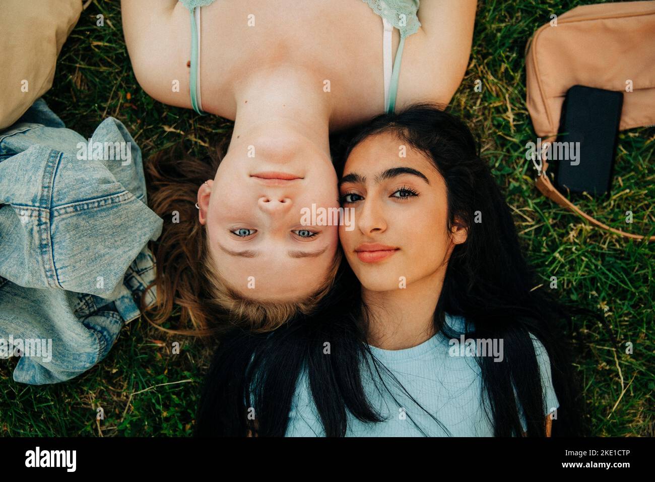Portrait des adolescentes couchée ensemble sur l'herbe au parc Banque D'Images