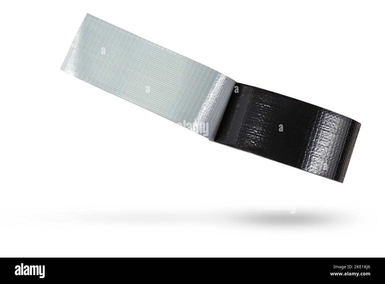 Rouleau de ruban adhésif noir isolé sur fond blanc. Le ruban adhésif noir renforcé tombe, jetant une ombre. Rouleau de ruban isolant non enroulé. Banque D'Images