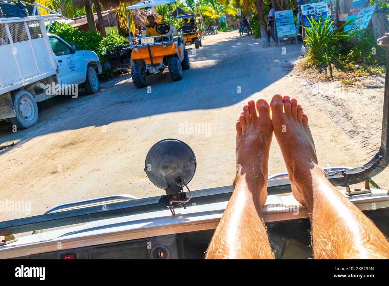 Promenade en voiturette de golf avec les pieds vers le haut sur l'île Isla Holbox à Quintana Roo Mexique. Banque D'Images