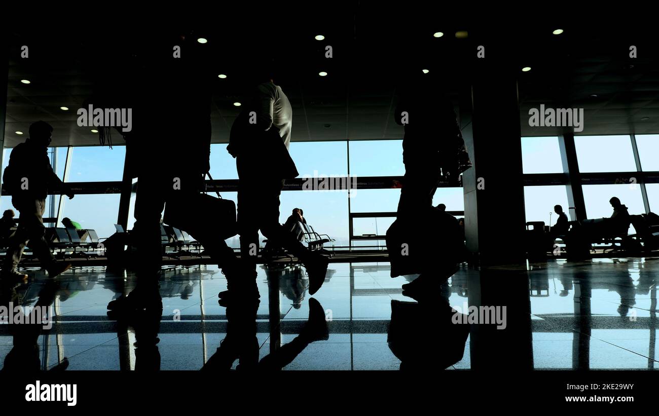 à l'aéroport, dans la salle d'attente, sur le fond de la fenêtre donnant sur les avions et la piste, les silhouettes marchent, ils se précipitent sur leurs vols. Photo de haute qualité Banque D'Images