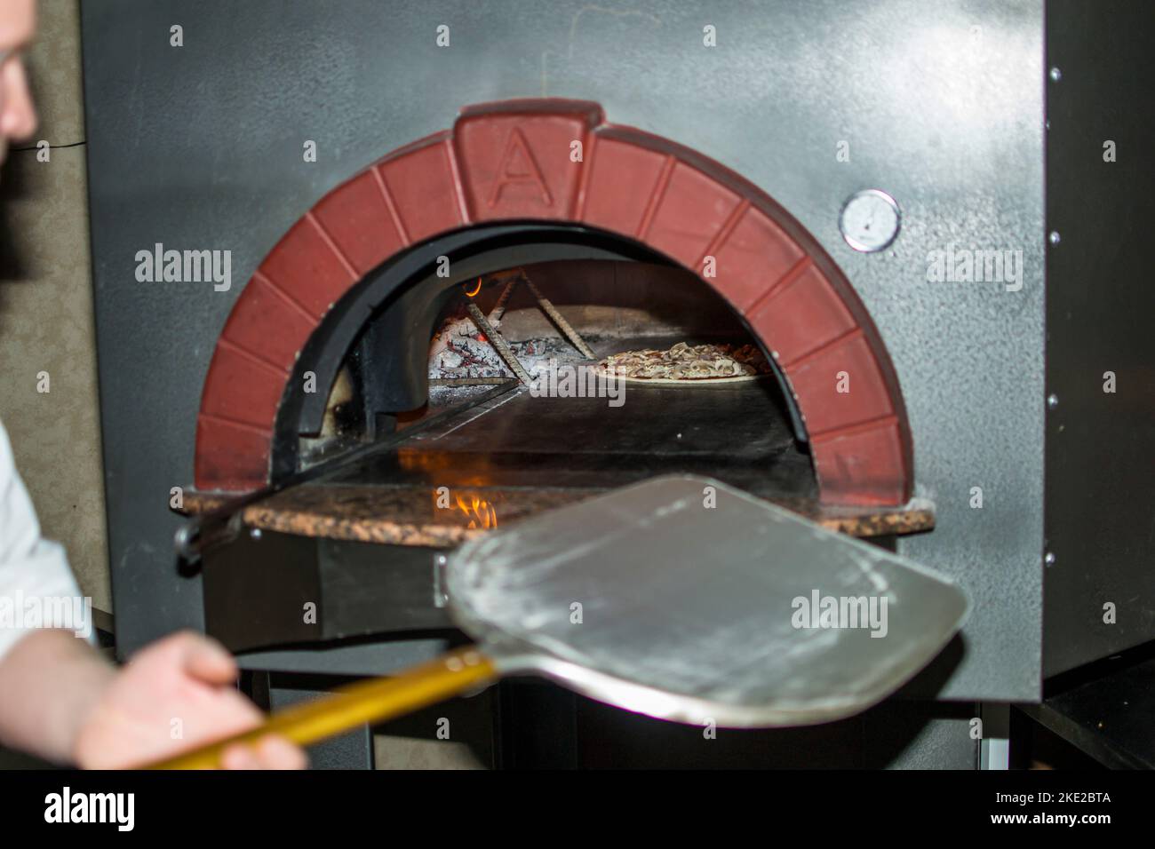 cuisson de la pizza au four . Pizza près du poêle à pierre avec feu. Arrière-plan d'un restaurant pizzeria traditionnel avec cheminée. Banque D'Images cuisson de la pizza au four . Pizza près du poêle à pierre avec feu. Arrière-plan d'un restaurant pizzeria traditionnel avec cheminée. Banque D'Images