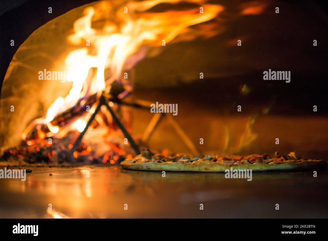 cuisson de la pizza au four . Pizza près du poêle à pierre avec feu. Arrière-plan d'un restaurant pizzeria traditionnel avec cheminée. Banque D'Images cuisson de la pizza au four . Pizza près du poêle à pierre avec feu. Arrière-plan d'un restaurant pizzeria traditionnel avec cheminée. Banque D'Images