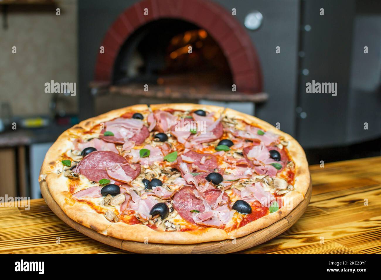 cuisson de la pizza au four . Pizza près du poêle à pierre avec feu. Arrière-plan d'un restaurant pizzeria traditionnel avec cheminée. Banque D'Images cuisson de la pizza au four . Pizza près du poêle à pierre avec feu. Arrière-plan d'un restaurant pizzeria traditionnel avec cheminée. Banque D'Images