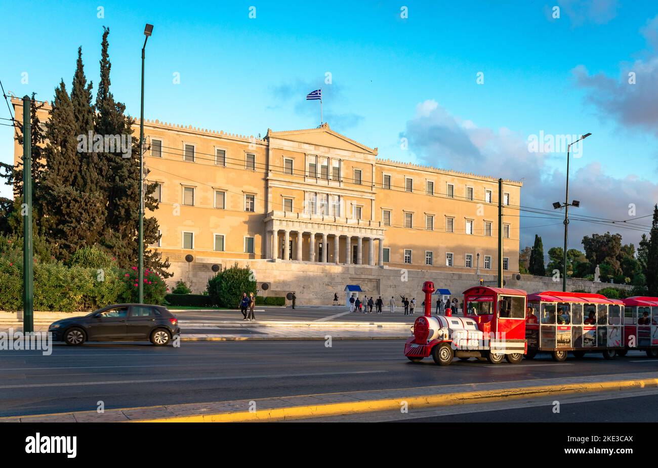 La façade du Parlement hellénique (grec), située dans l'ancien palais royal surplombant la place Syntagma et le bus à arrêts multiples du Happy train d'Athènes. Banque D'Images