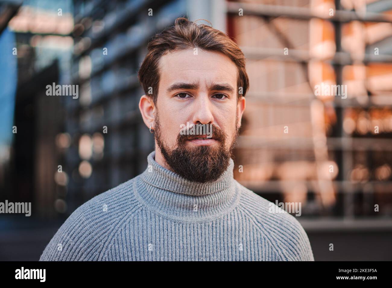 Portrait en gros plan d'un jeune homme caucasien isolé à l'extérieur. Photoshhot des émotions réelles du modèle masculin. Debout et semble sérieux. Expression faciale Banque D'Images