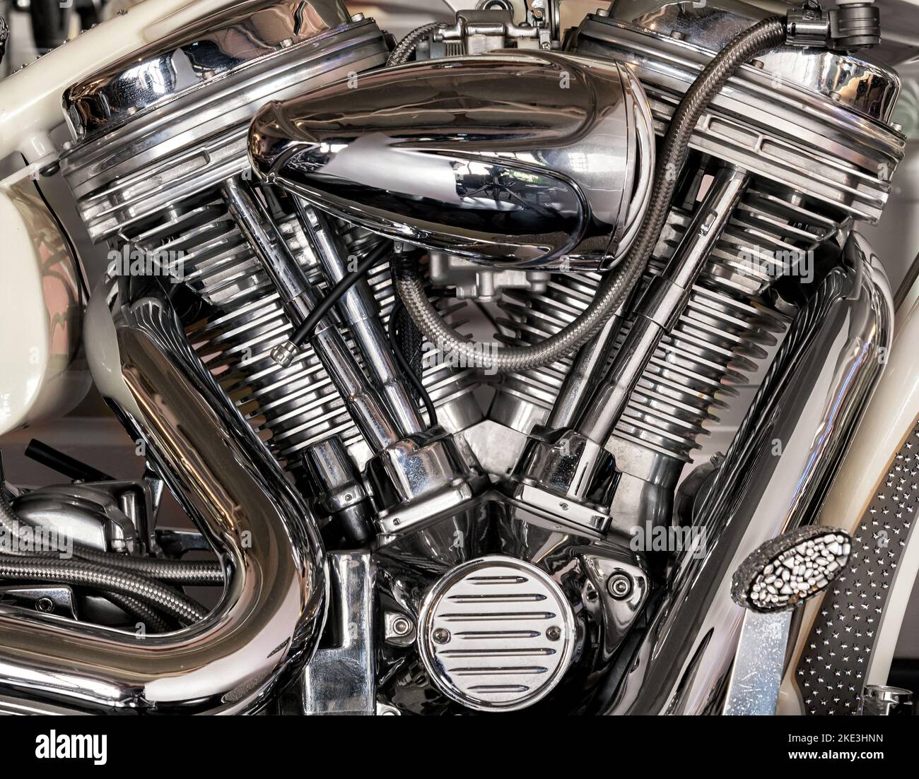 Gros plan des détails chromés brillants d'un moteur de moto moderne stationné dans un garage en journée Banque D'Images