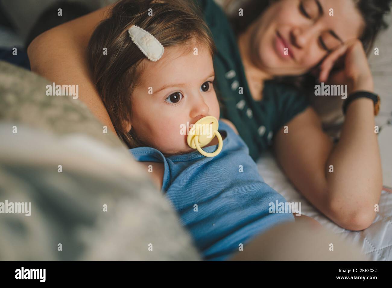 Mère et sa fille enfant fille jouant et s'embrassant en étant allongé dans le lit. Bonne famille aimante. Concept de fête des mères. Un style de vie heureux. Aimez les gens Banque D'Images