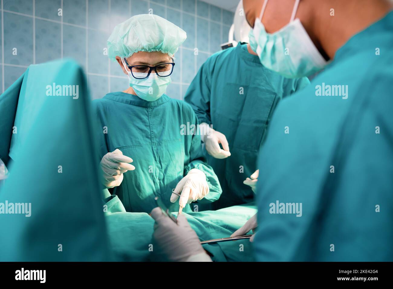 Groupe de chirurgiens au travail dans la salle d'opération de l'hôpital Banque D'Images Groupe de chirurgiens au travail dans la salle d'opération de l'hôpital Banque D'Images