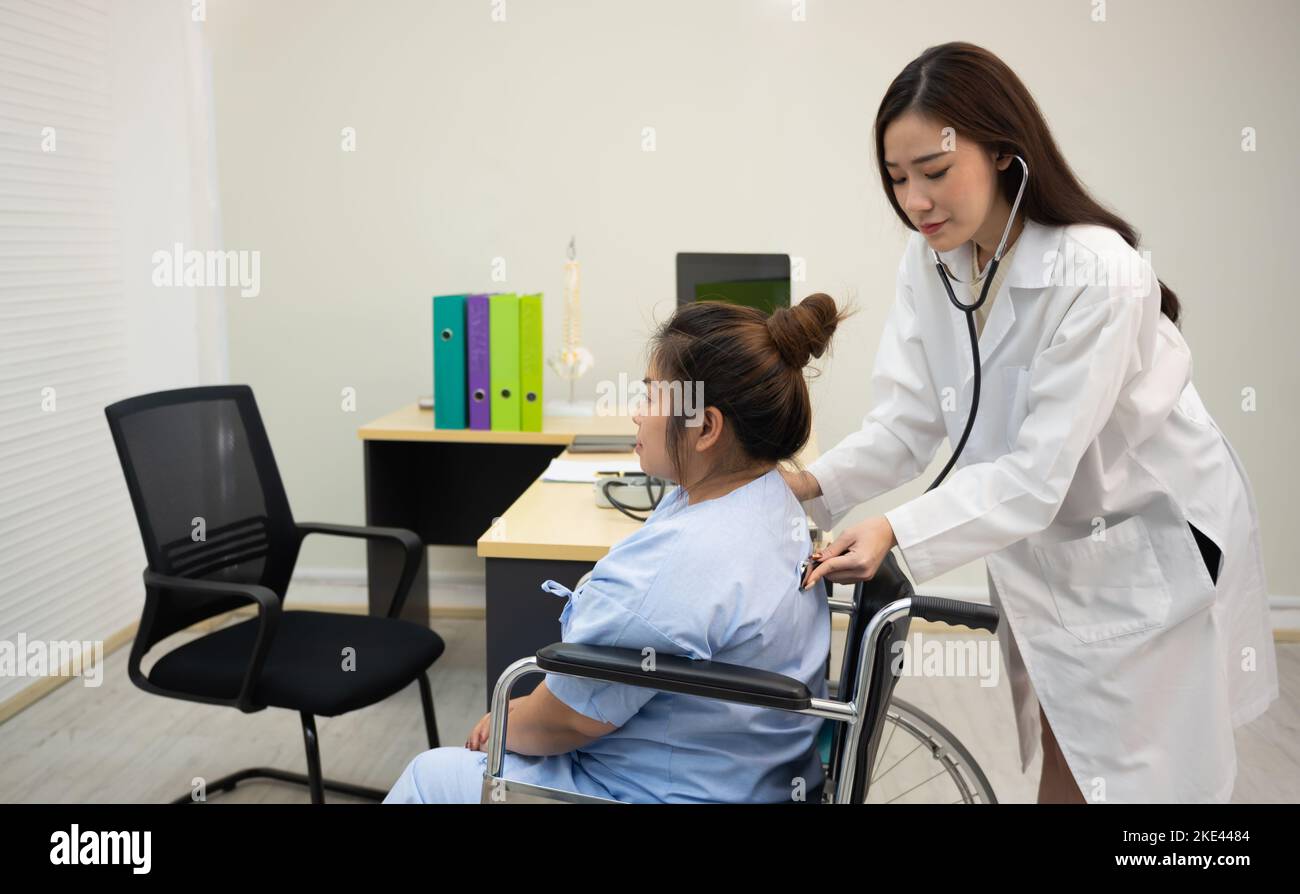 Les médecins écoutent le dos du patient à l'aide d'un stéthoscope pour détecter les bruits internes. Banque D'Images