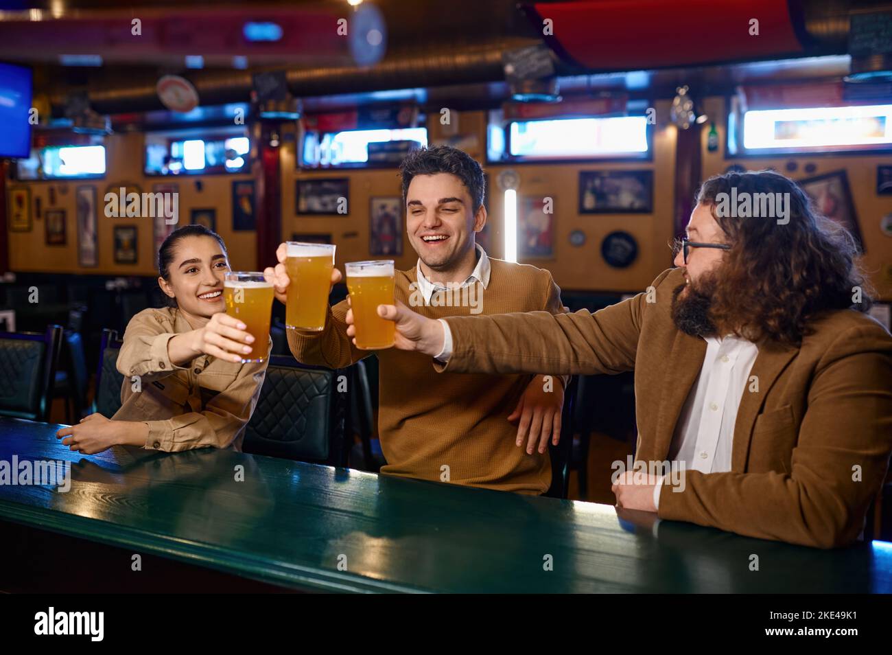 Groupe d'amis heureux se reposant et parlant au bar Banque D'Images