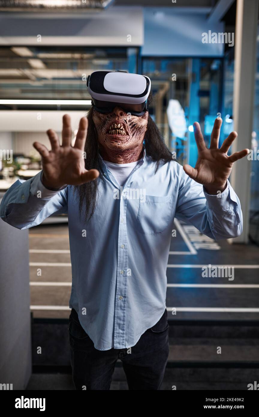 Employé de bureau zombie utilisant un casque de simulateur VR Banque D'Images
