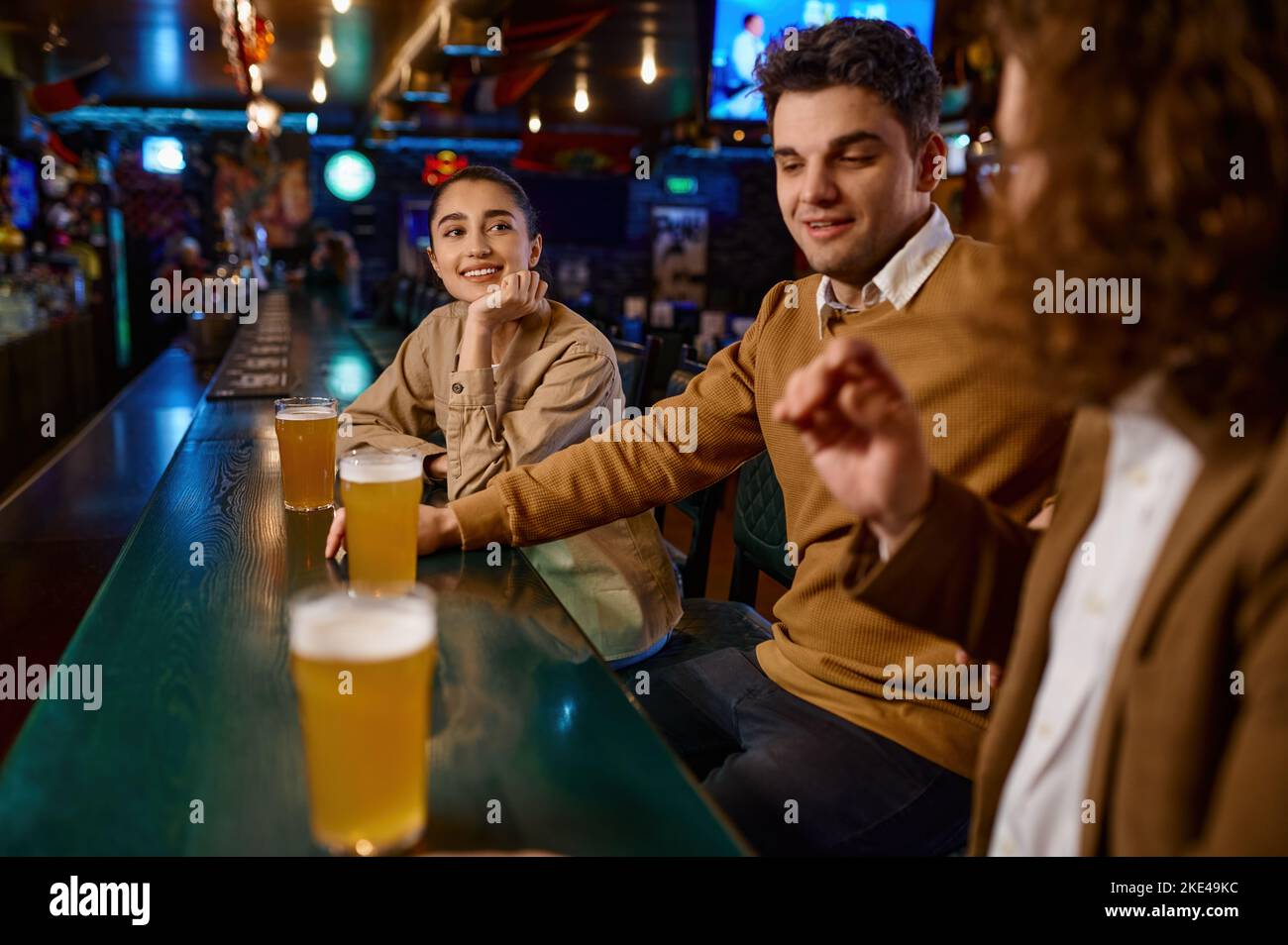 Groupe d'amis heureux se reposant et parlant au bar ou au pub Banque D'Images