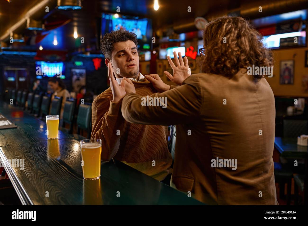 Deux fans de football se battent au comptoir du bar sportif Banque D'Images