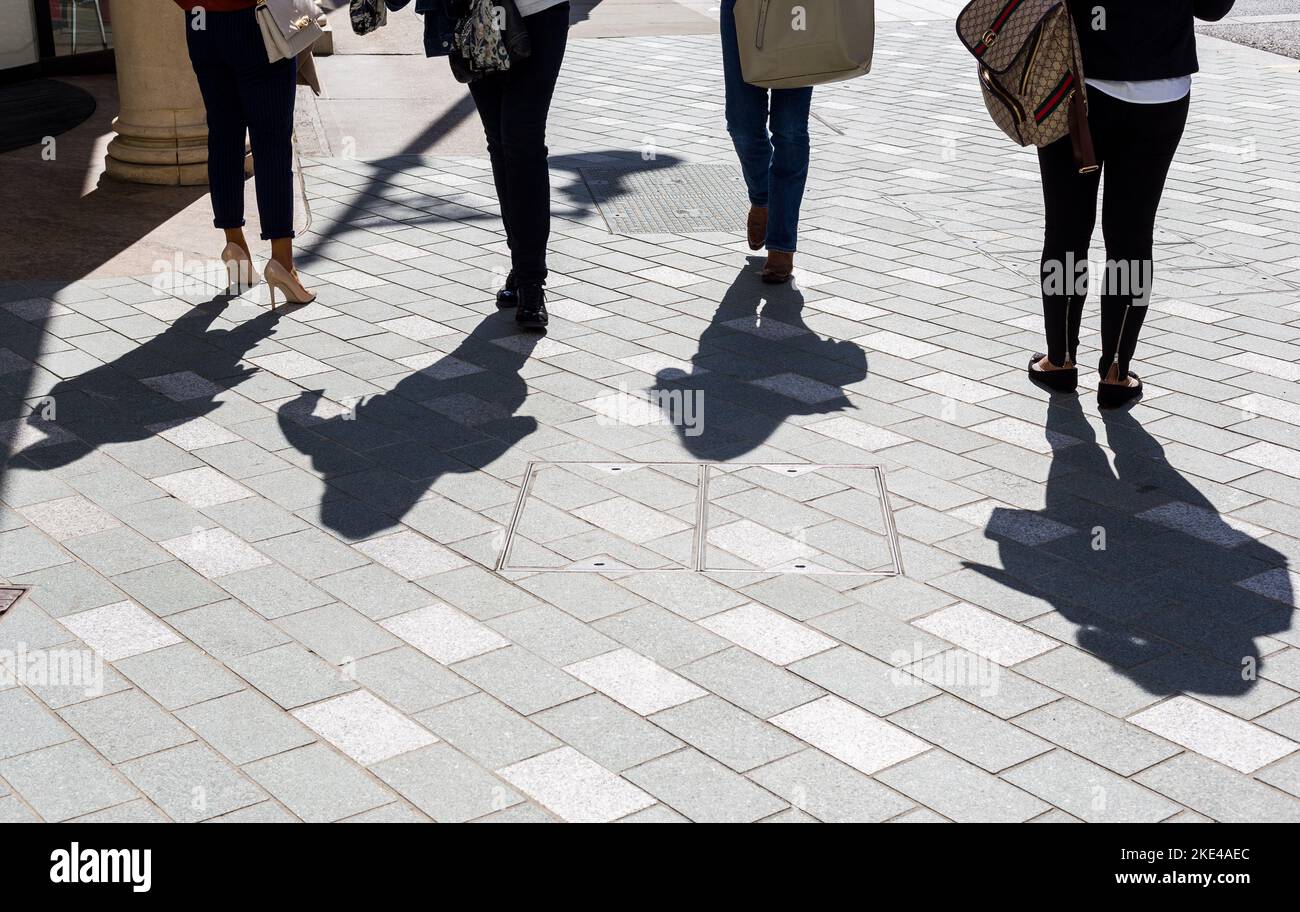 Quatre femelles avec de fortes ombres marchant le long de la célèbre rue Bond Street.concept de Londres pourrait inclure le marché et la mode. Banque D'Images