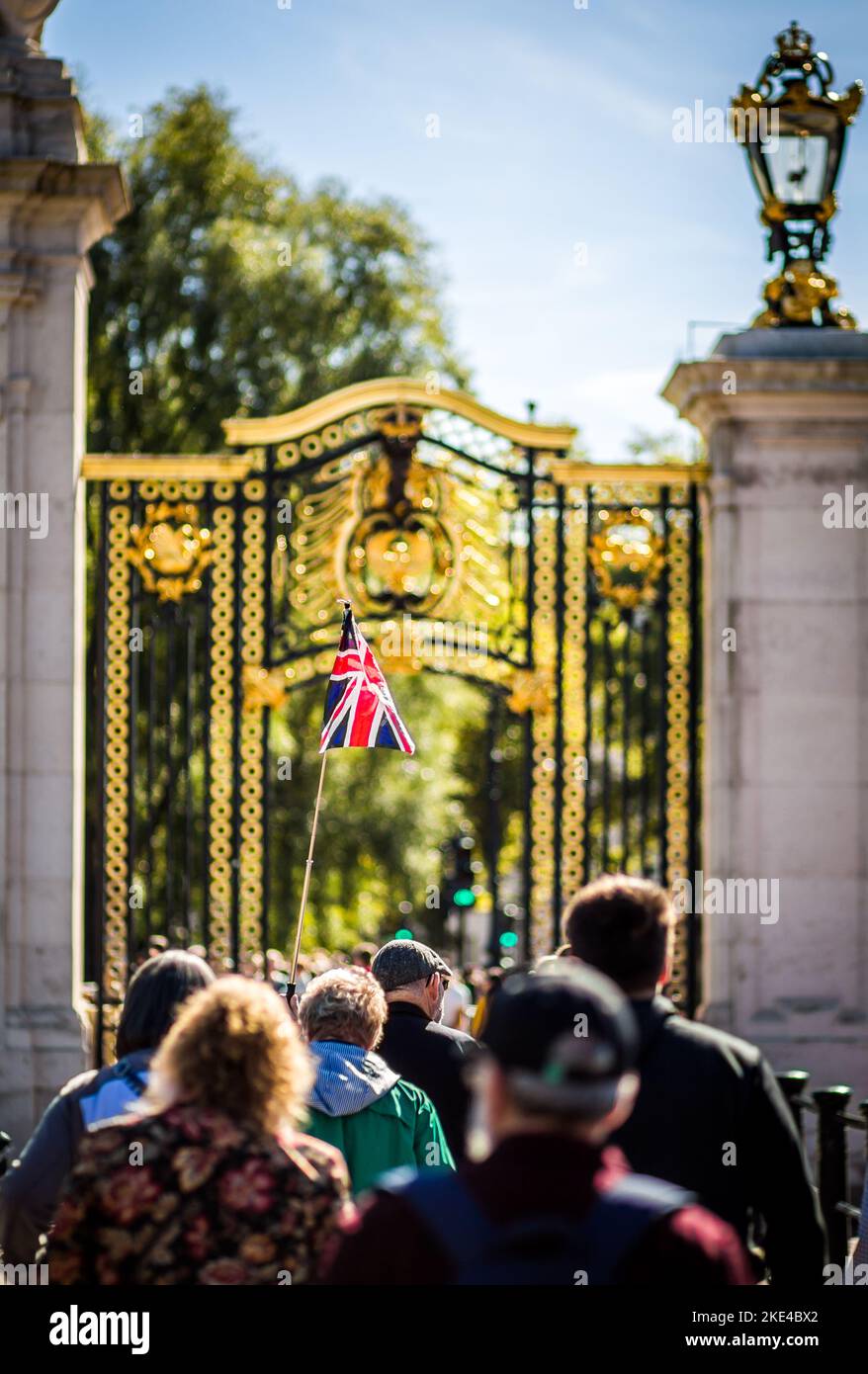 Les touristes affluent à Londres pour visiter Buckingham Palace.ici, un guide avec un drapeau de l'Union le place au-dessus de la foule pour les touristes suivants Banque D'Images