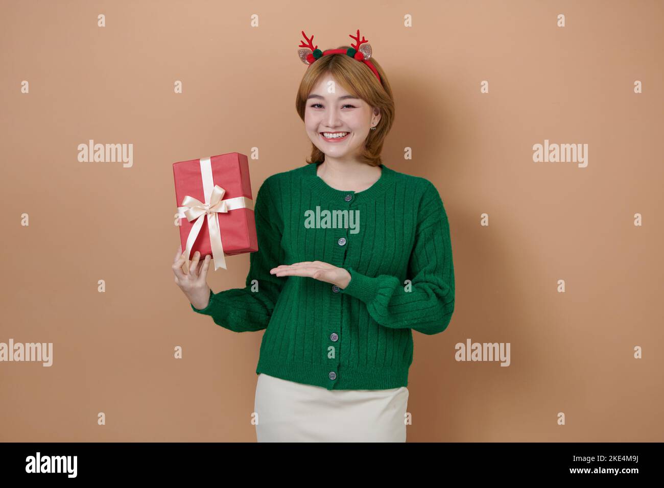 femme portant des cornes de cerf tenant une boîte cadeau joyeux noël joyeux de la nouvelle année concept Banque D'Images