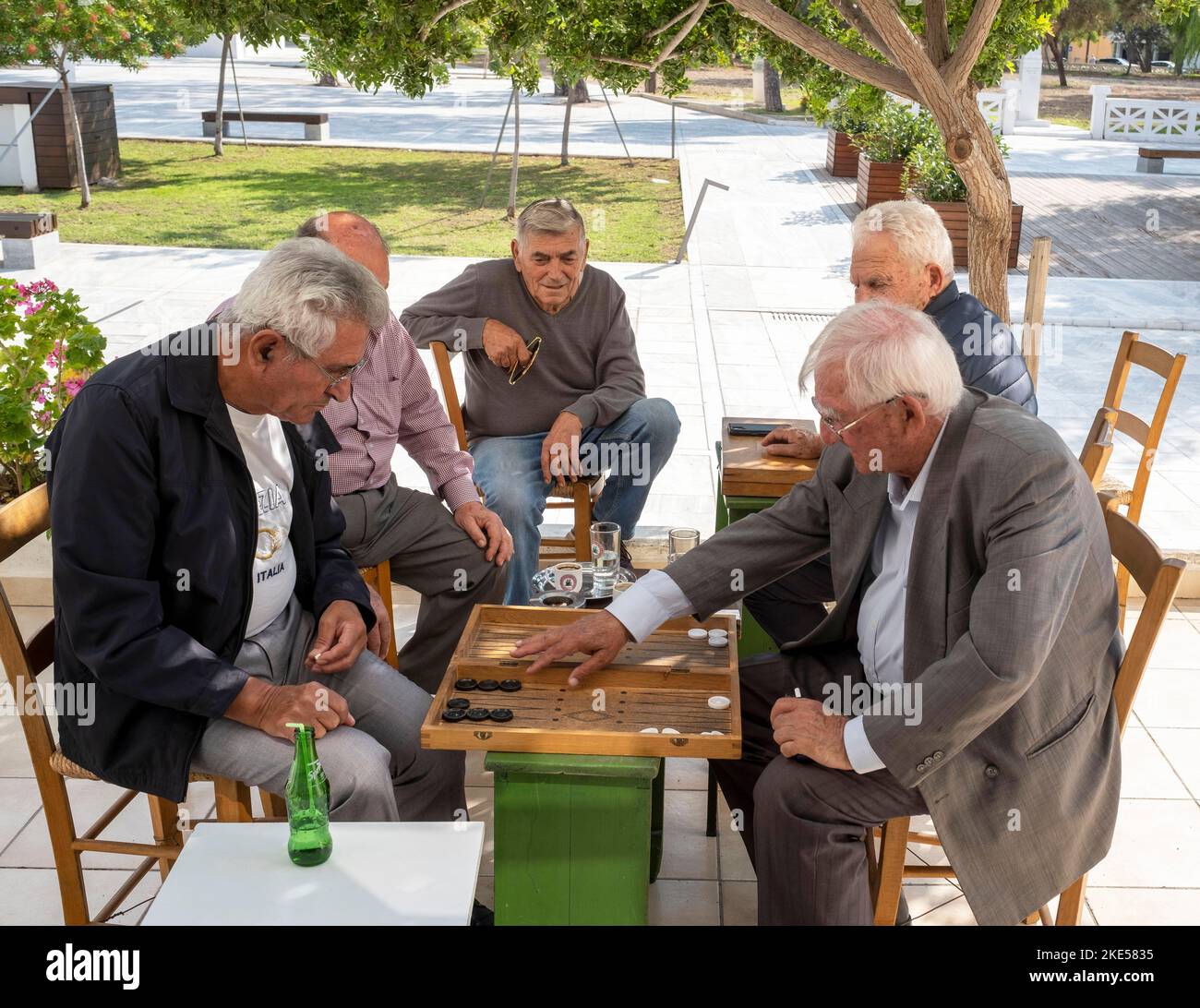 Un groupe d'hommes seniors jouant au jeu de société de backgammon, centre-ville de Pafos, Chypre. Banque D'Images