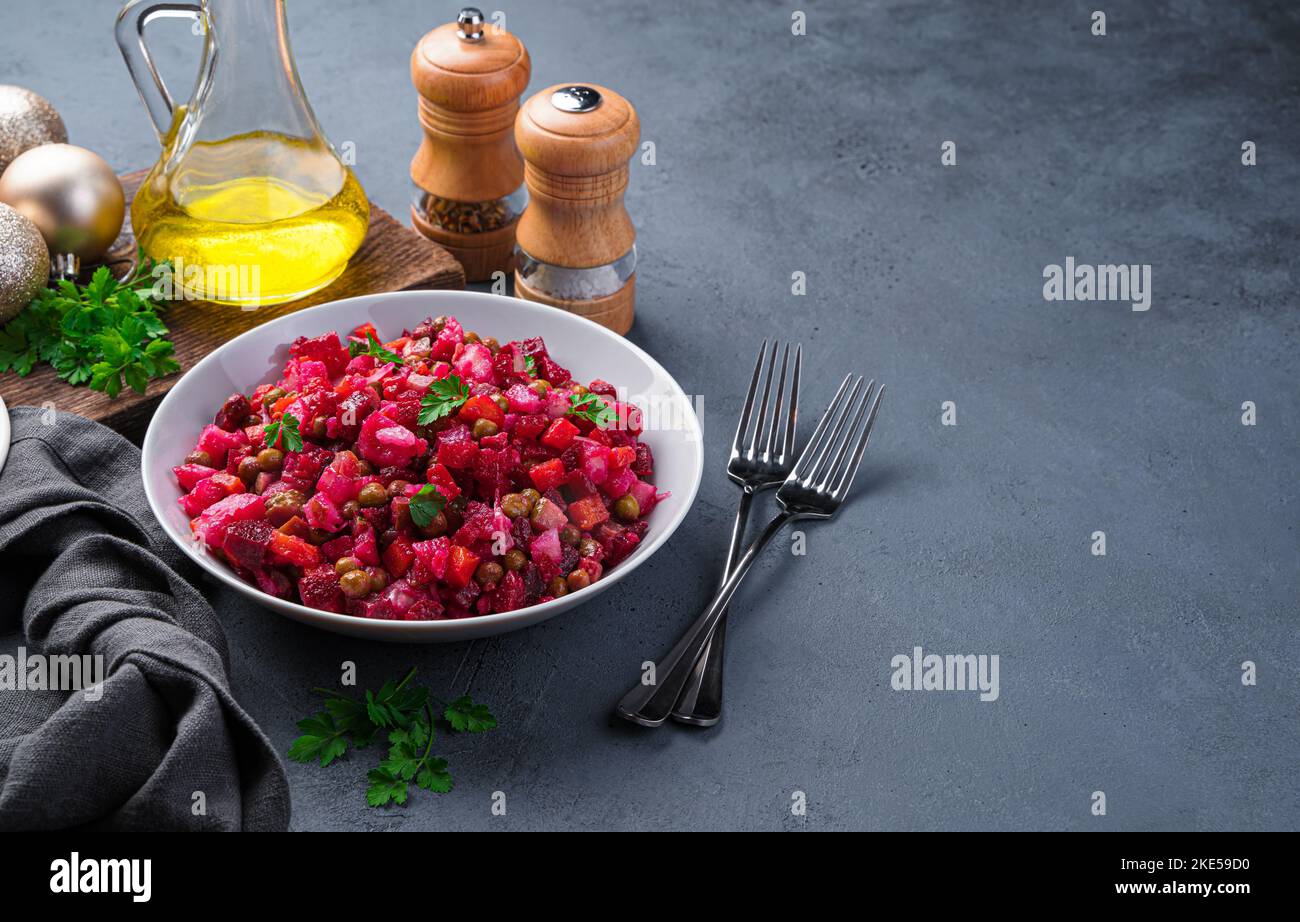 Vinaigrette à salade traditionnelle sur fond sombre. Salade avec légumes, petits pois et herbes fraîches. Banque D'Images
