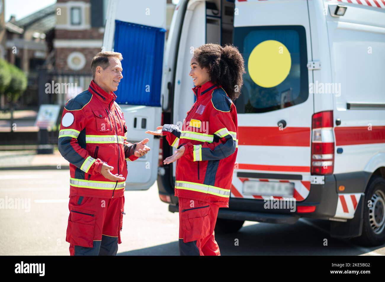 Médecins ambulanciers joyeux ayant une conversation à l'extérieur Banque D'Images