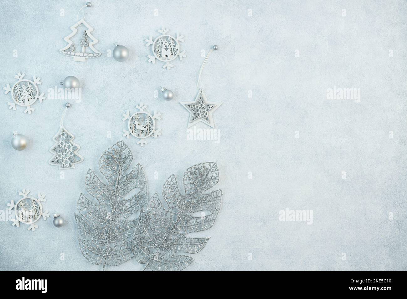 Le concept d'un fond de fête dans des tons argentés. Vue de dessus des boules argentées de la boîte cadeau sur fond gris. Arrière-plan des fêtes du nouvel an Banque D'Images