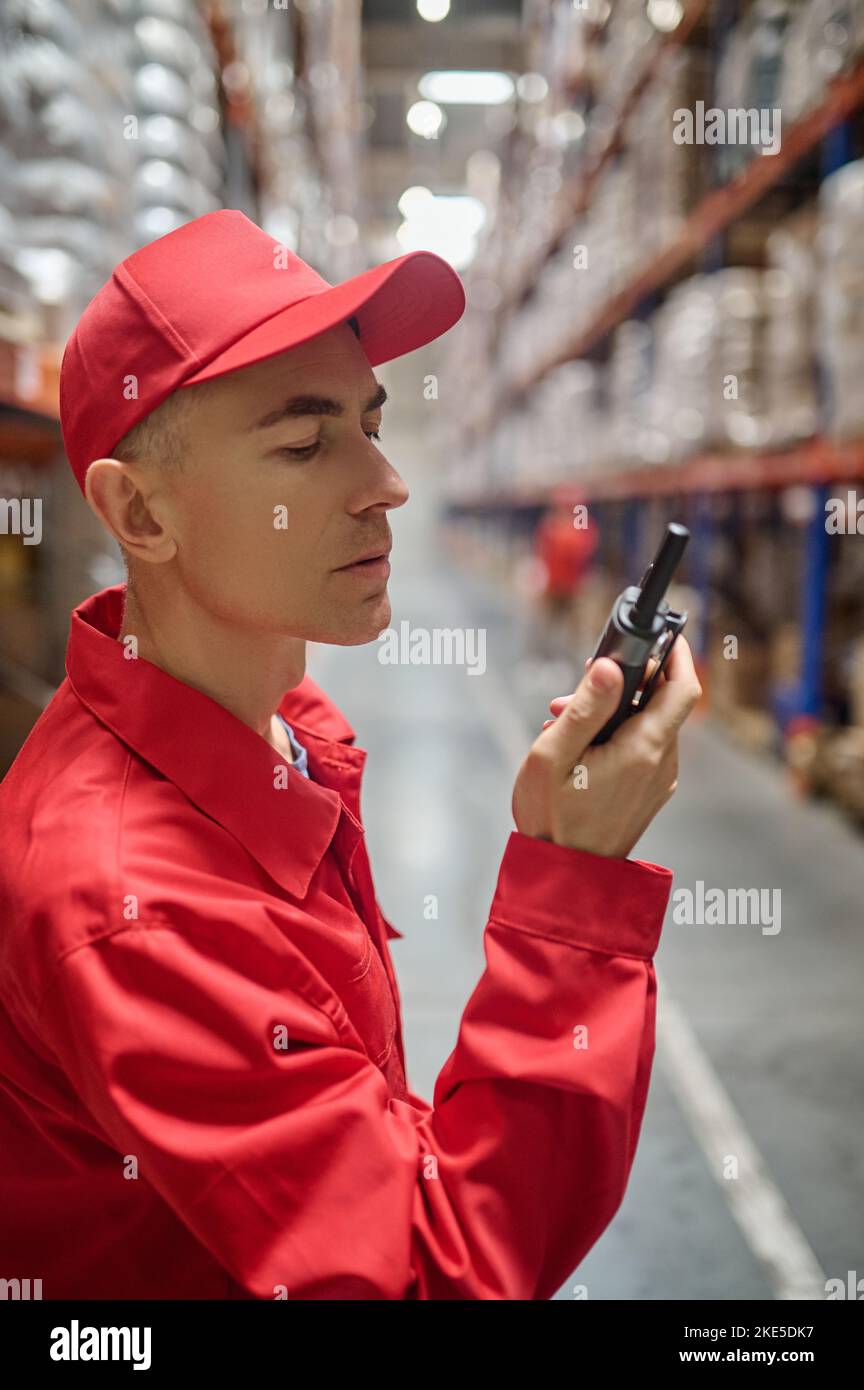 Employé utilisant la radio professionnelle dans la zone de stockage Banque D'Images