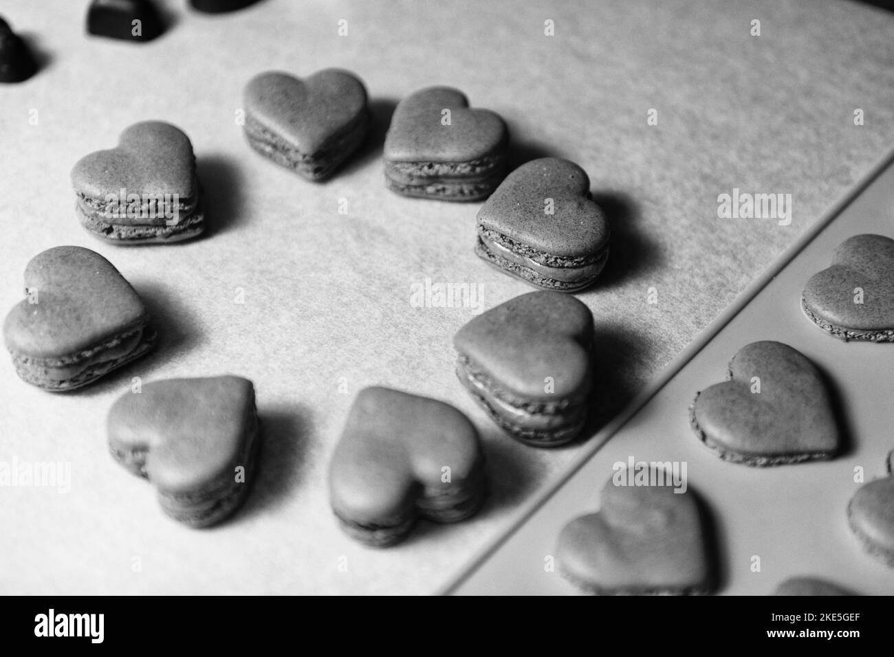 Macarons à coeur noir et blanc dessert sur papier sulfurisé Banque D'Images